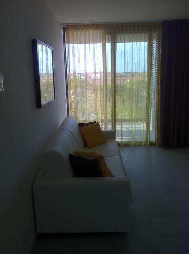 a living room with a couch and a large window at Residence Ormeggio in Grado