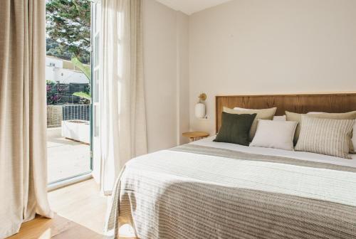 a bedroom with a bed and a large window at Sant Patrici Hotel in Ferreries