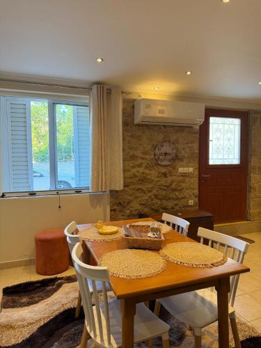 a dining room with a wooden table and chairs at To Petrino apartment in Kyparissia