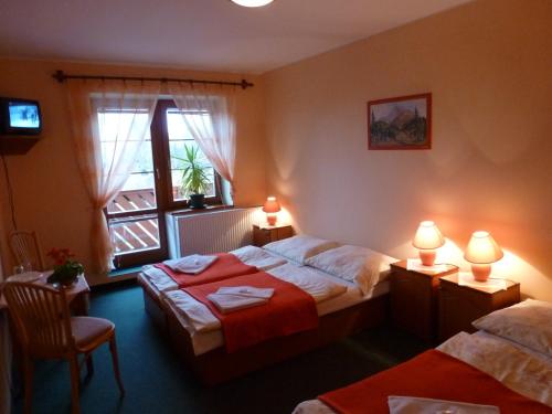 a hotel room with two beds and a window at Erika penzión in Vysoke Tatry - Tatranska Lesna