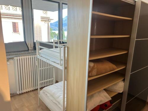 a room with a closet with shelves and a window at Inaya Apartment in Oggebio