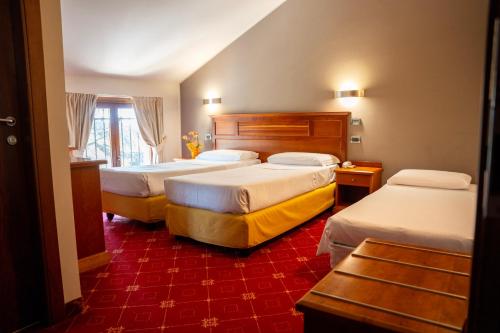 a hotel room with three beds and a red carpet at La Pina in Rezzato