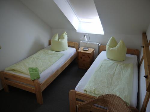 a bedroom with two beds and a table and a lamp at Lindenhof Helmke in Schellerten