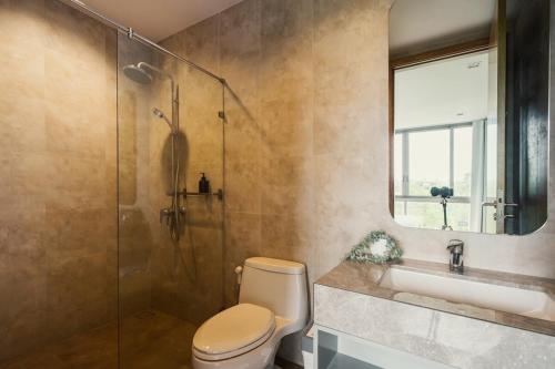 a bathroom with a shower and a toilet and a sink at Sandbox Beachfront Villa 6 in Ban Krathing Lai