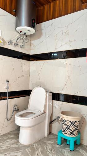 a bathroom with a white toilet and a sink at Romantic loft with mountain view in manali in Haripūr