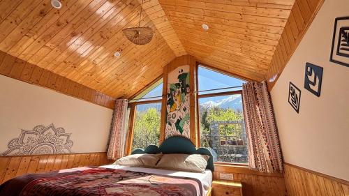 a bedroom with a bed and a large window at Romantic loft with mountain view in manali in Haripūr