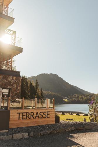 a sign for the terrace of a resort with a lake at Alpin Peaks in Turracher Hohe