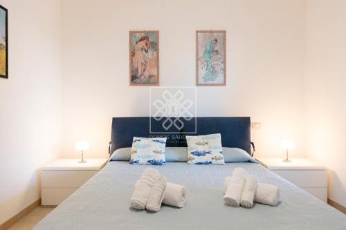 a bedroom with a bed with two towels on it at Villino Joy in Stintino