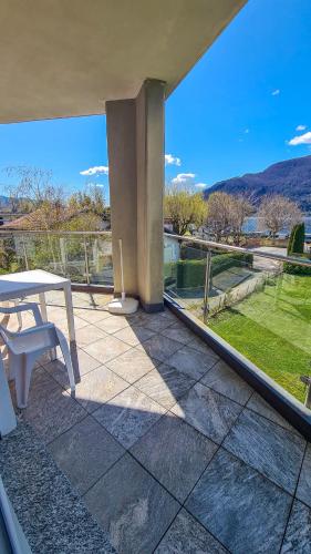 a patio with a table and a view of a field at Casa Belfiore in Maccagno Superiore