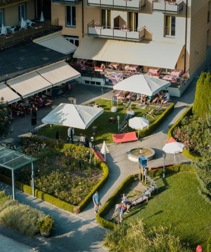 an aerial view of a courtyard with umbrellas and a fountain at Hotel Victoria Lauberhorn Wengen, a Faern Collection Hotel in Wengen