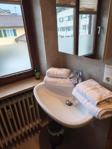 a bathroom with a sink and a window and towels at Apartment King Louie in Prien am Chiemsee