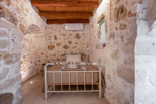 a room with a bed in a stone wall at MERAKI residence in Atsipopoulo