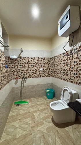 a bathroom with a toilet and a sink at Akari Inn in Haripūr