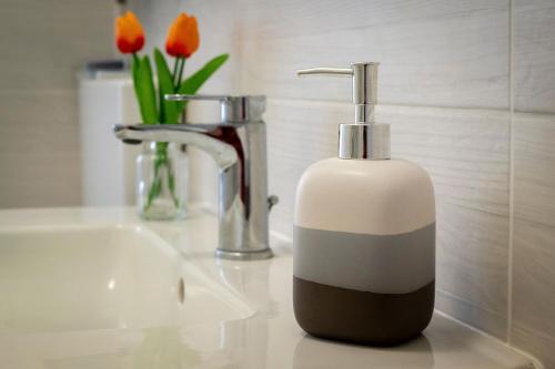 a soap dispenser sitting on a sink next to flowers at La casa di Ros in Perinaldo