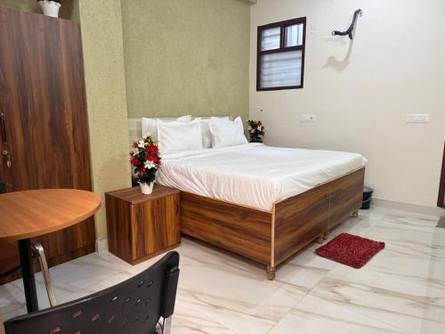 a bedroom with a bed and a table and a table at JMD Zoom Plaza Hotel in Farrukhnagar