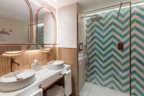 a bathroom with two sinks and a shower at Vincci Resort Costa Golf in Chiclana de la Frontera