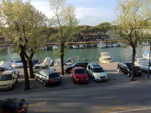 a group of cars parked in a parking lot near a river at Residence Ormeggio in Grado