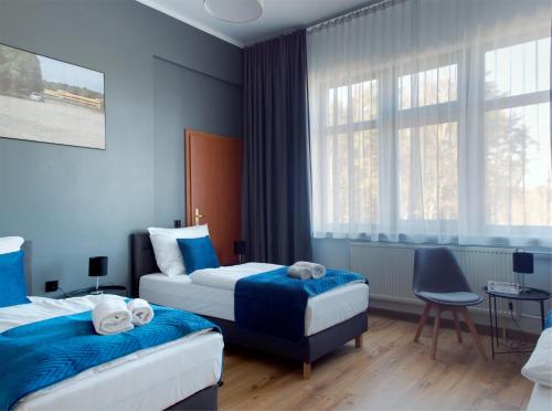 a hotel room with two beds and a window at Hotel Tor Kielce in Kielce