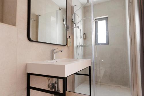 a bathroom with a sink and a shower at Zyra Hotel St Julians - Adults only in St. Julianʼs