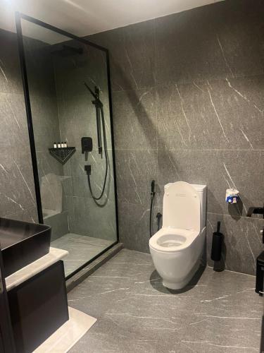 a bathroom with a shower and a white toilet at Hirolagos in Bamgbose