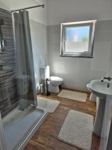 a bathroom with a shower and a sink and a toilet at Flat near Serra da Arrábida, beaches and Lisbon in Quinta do Conde