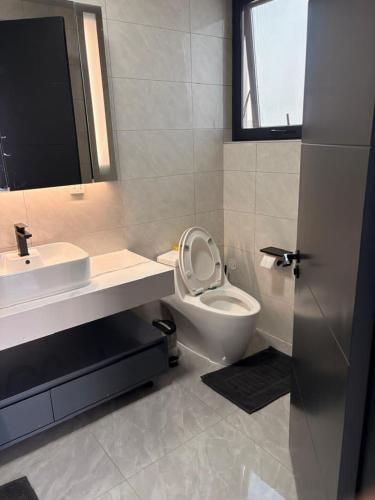 a bathroom with a toilet and a sink and a mirror at Blue Diamond Luxe in Gaborone