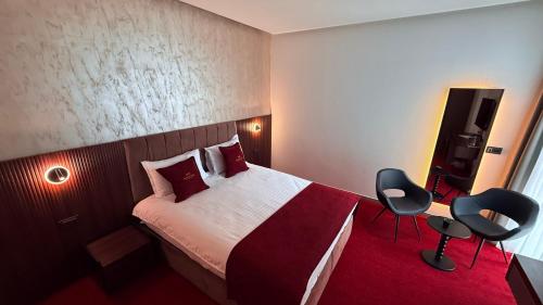 a hotel room with a bed and two chairs at MY HOTEL in Prizren