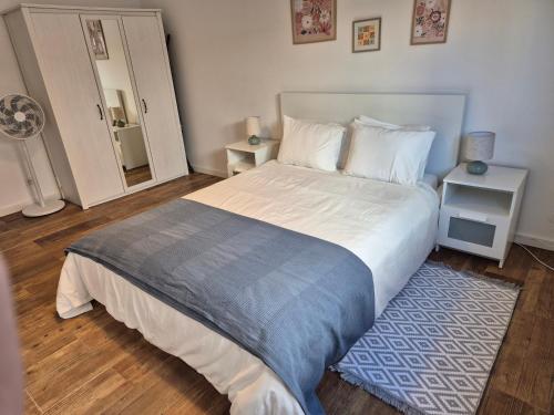 a bedroom with a large bed and a blue rug at Flat near Serra da Arrábida, beaches and Lisbon in Quinta do Conde