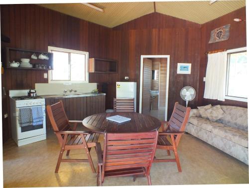 a kitchen and dining room with a table and chairs at Broome Bird Observatory in Broome