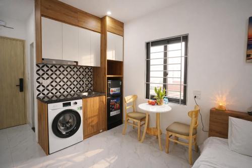 a kitchen with a washing machine and a table at Green West Lake Residence in Hanoi