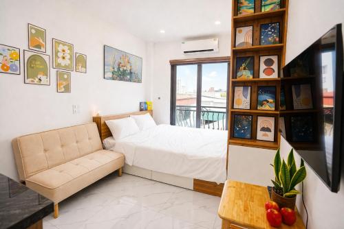 a bedroom with a bed and a couch and a window at Green West Lake Residence in Hanoi