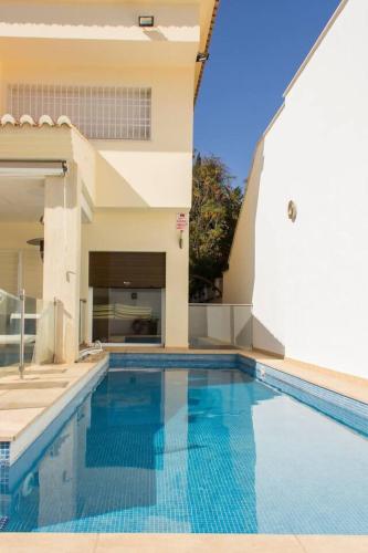 a swimming pool in front of a house at August Villa Málaga. Relax Playa Piscina Coworking in Málaga