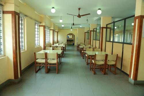 a row of tables and chairs in a restaurant at Hotel Nandanam in Guruvāyūr