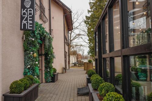 a sidewalk in front of a building with plants at Hotel Pils with Self-Check in in Sigulda