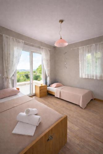 a bedroom with two beds and a large window at Sunrise Villa in Kassandra