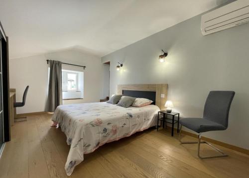 a bedroom with a bed and a chair at Elizetxea in Larceveau-Arros-Cibits