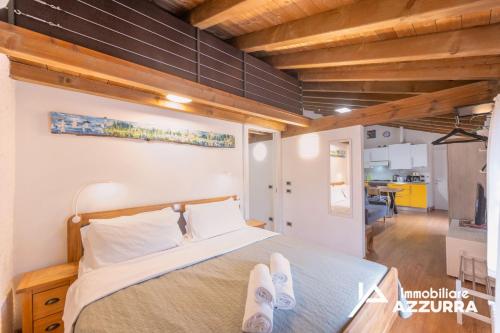a bedroom with a bed with two feet on it at Aly d'Angelo alla Torre - Immobiliare Azzurra in Bardolino