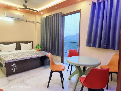 a bedroom with a bed and a table and chairs at Fng Guest House in Noida