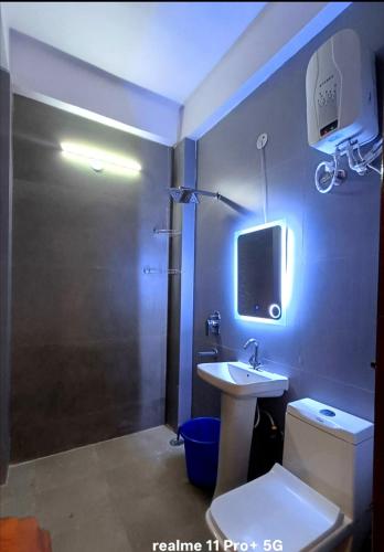 a bathroom with a sink and a tv on the wall at Fng Guest House in Noida