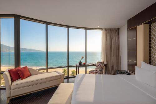a bedroom with a bed and a view of the ocean at Holiday Beach Hotel Danang in Danang