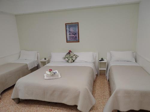 a room with three beds and a tray with flowers on it at B&B Maestra Giovanna in Pompei