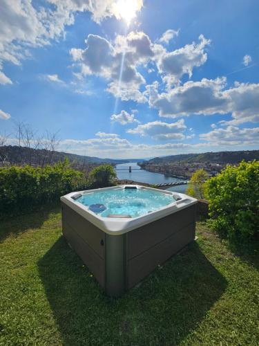 a hot tub on the grass with a view of a river at La Bâtie - Jacuzzi - Vue - Amazing view - Parking privé in Vienne