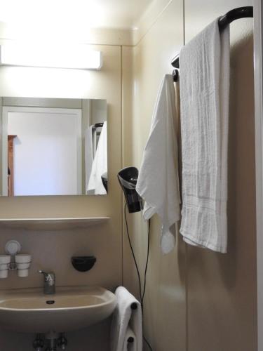 a bathroom with a sink and a mirror and towels at Hotel Argo Lindau in Lindau