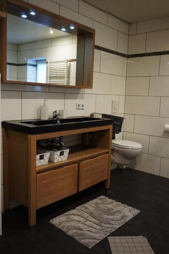 a bathroom with a sink and a toilet at Leuchtturmnest in Krummhörn