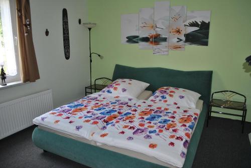 a bed in a bedroom with a bedspread with flowers on it at Ferienwohnung Thiedmann in Hagebök