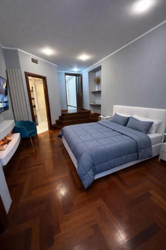 a bedroom with a large blue bed and wooden floors at FRASCATI Suites in Frascati