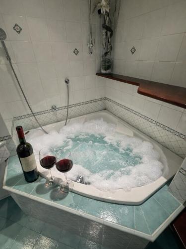 a bath tub with two glasses of wine in it at FRASCATI Suites in Frascati