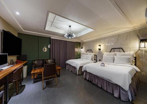 a hotel room with two beds and a desk at Browndot Hotel Daegu Exco branch in Daegu