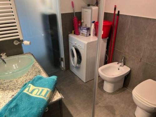 a bathroom with a sink and a washing machine at Inaya Apartment in Oggebio