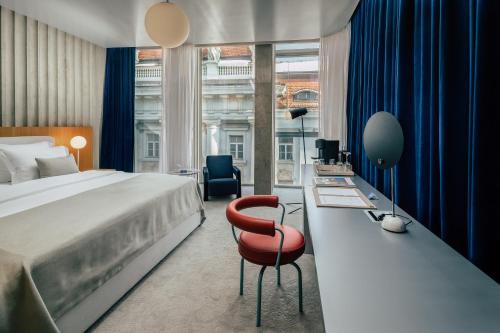 a bedroom with a bed and a desk with a chair at Met Boutique Hotel in Zagreb